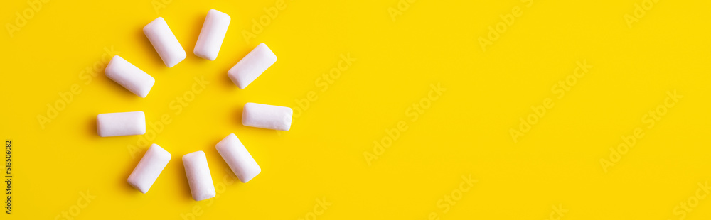 Top view of round shape from white chewing gums on yellow background, banner. Top view of round shape from white chewing gums on yellow background, banner.