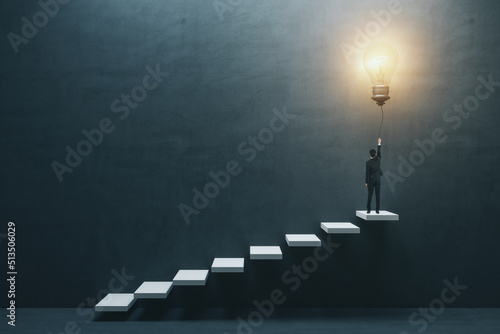 Innovation and idea concept with man in suit back view on the top of white stairway turning on big light bulb on dark concrete background