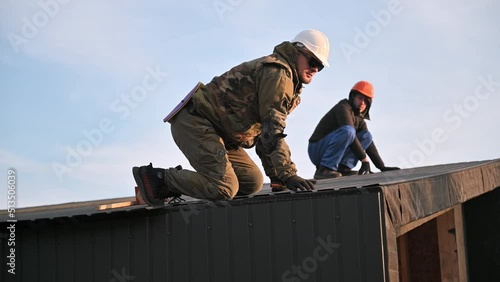 Wallpaper Mural Man worker building wooden frame house. Builder using tape measure for measuring corrugated sheets on roof. Torontodigital.ca