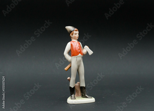 Mid-century modern porcelain figurine - little lumberjack boy isolated on black background photo