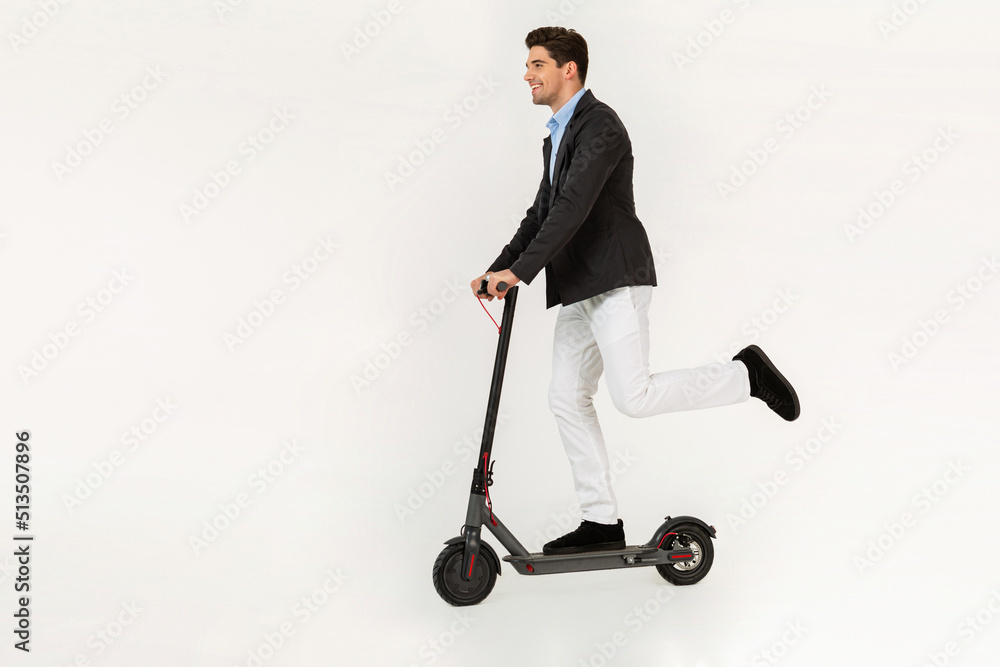 handsome man riding on electic kick scooter isolated on white studio background handsome man riding on electic kick scooter isolated on white studio background
