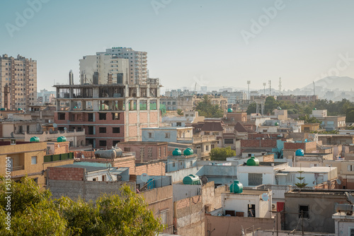 Wide panoramic view of African city of Oran in Algeria, shot of residental buildings and dirty facades on a sunny day with clear skies. © Anze