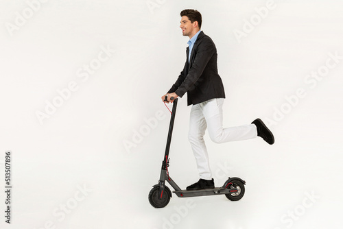 handsome man riding on electic kick scooter isolated on white studio background photo