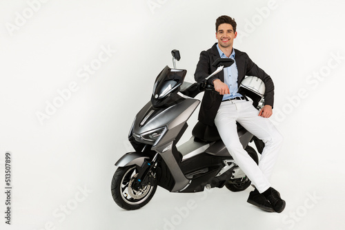 handsome man riding on electic motorbike scooter isolated on white studio background