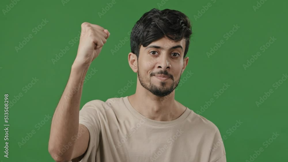 Arabian motivated activist young indian man raises clenched male fist in air demonstrate unity power sign pride symbol hispanic handsome strong guy smiling feel energy shows support gesture solidarity Arabian motivated activist young indian man raises clenched male fist in air demonstrate unity power sign pride symbol hispanic handsome strong guy smiling feel energy shows support gesture solidarity