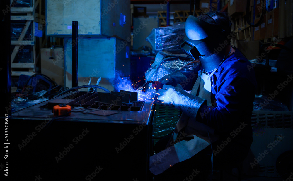 A welder is working to weld metal. to create quality work according to the prescribed form A welder is working to weld metal. to create quality work according to the prescribed form