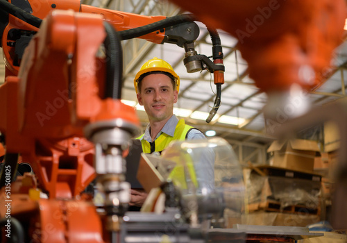 A male engineer checking the operation of a welding robot. used for precision welding control Fast and highly secure © Wosunan