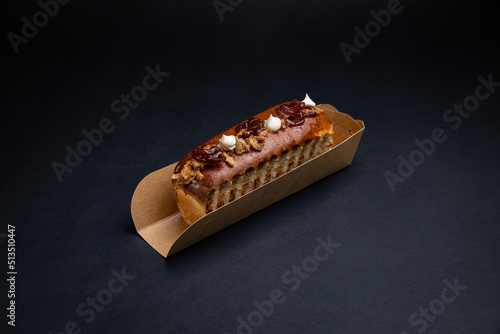 Hot dogs in paper plates with meat filling and sauce. On a black background
 photo