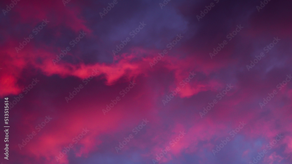 Reflets rougeoyants pendant le coucher du soleil, sous des nuages de haute altitude