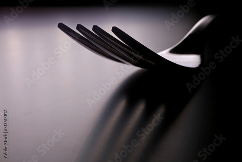 silhouette of a metal fork on dark background