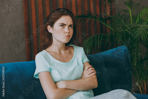 Canvastavla Young unhappy thoughtful upset minded pensive confused caucasian woman she 20s wearing casual clothes mint t-shirt sit on blue sofa indoor rest at home in own room apartment