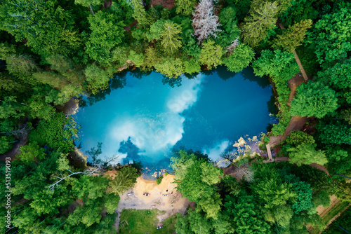 Fototapeta Naklejka Na Ścianę i Meble -  Blue lake in the middle of green forest, aerial view. Wild colorful lake in mountain park in Poland. Beautiful nature landscape