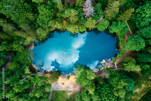 Blue lake in the middle of green forest  aerial view. Wild colorful lake in mountain park in Poland. Beautiful nature landscape