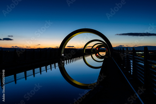 view of the Falkirk Wheel at sunset with lights in different bright colors photo