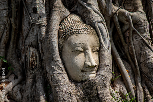 Ayutthaya Province,Thailand on May22,2020:Buddha's head in Bodhi tree roots at Wat Mahathat.A UNESCO World Heritage Site.