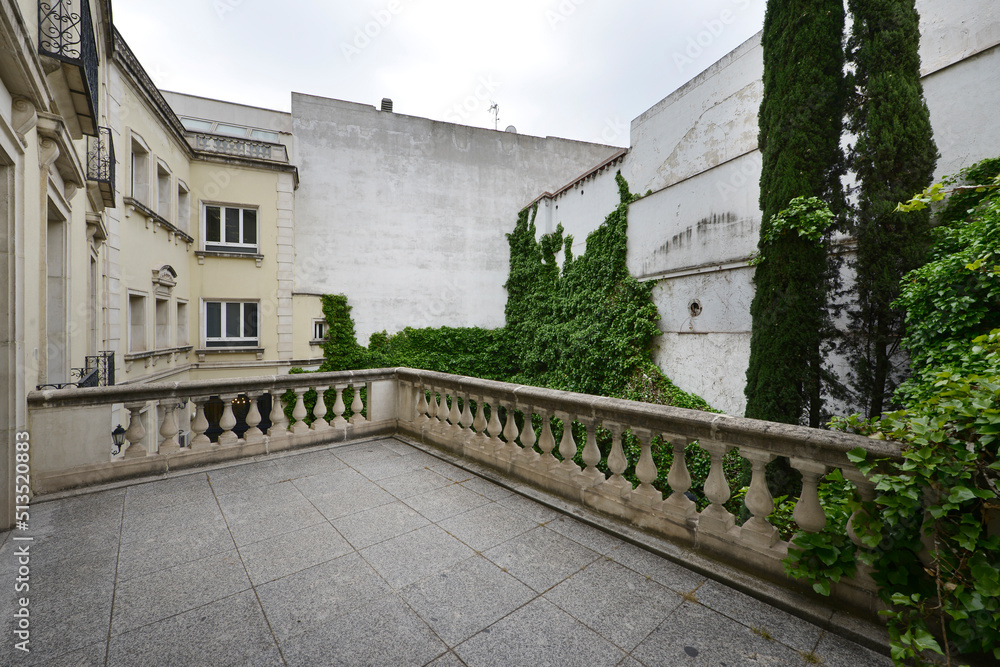 Interior terrace of a palace with climbing plant and cement balustrade
