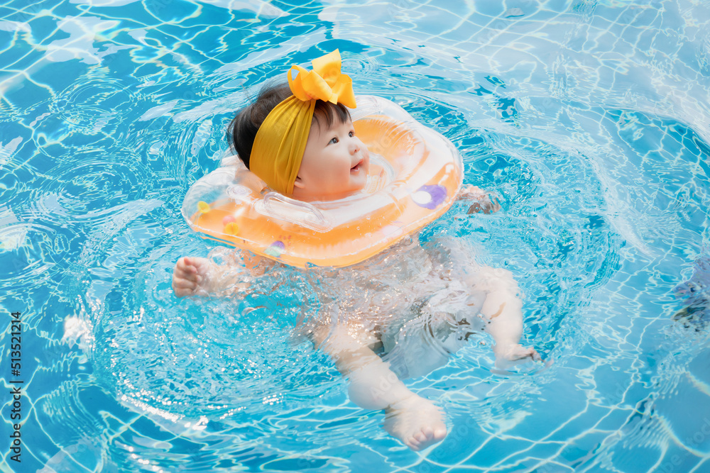 Asian happy cute baby swimming, smiling in a pool. 7 months baby in