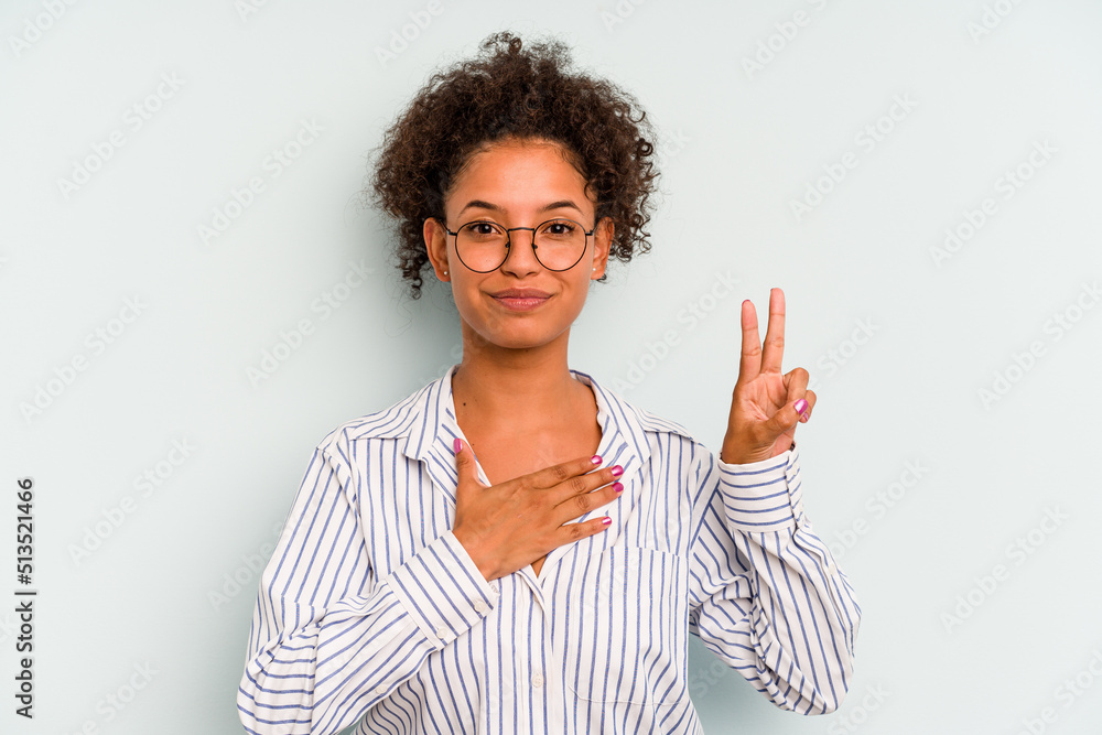Young Brazilian woman isolated on blue background taking an oath, putting hand on chest. Young Brazilian woman isolated on blue background taking an oath, putting hand on chest.