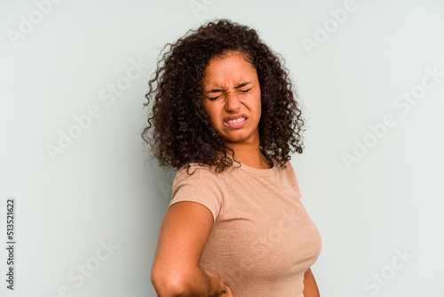 Young Brazilian woman isolated on blue background suffering a back pain.