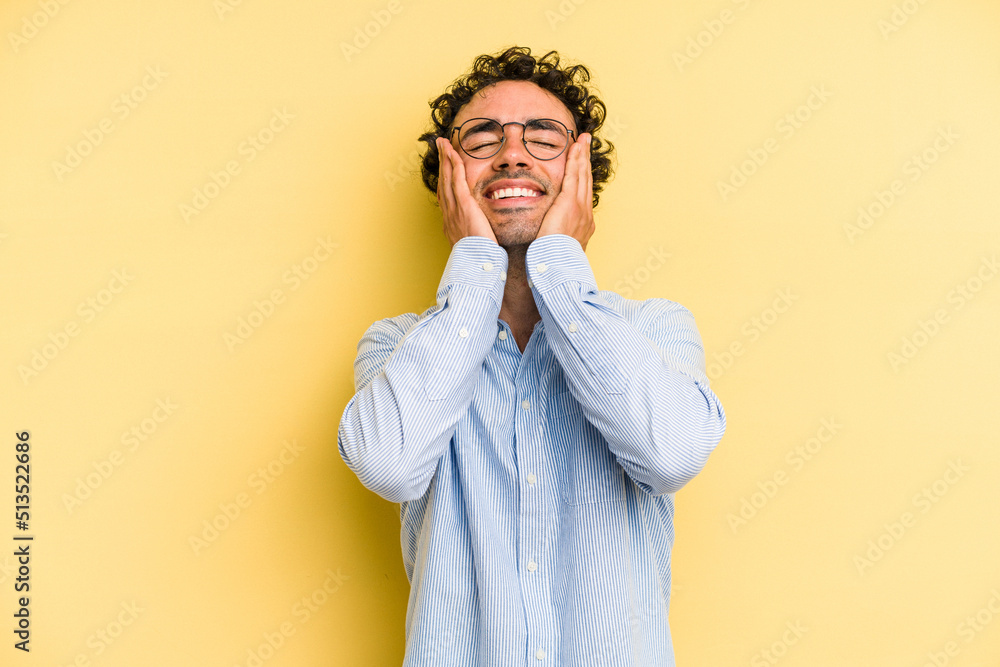 Young caucasian man isolated on yellow background laughs joyfully keeping hands on head. Happiness concept. Young caucasian man isolated on yellow background laughs joyfully keeping hands on head. Happiness concept.
