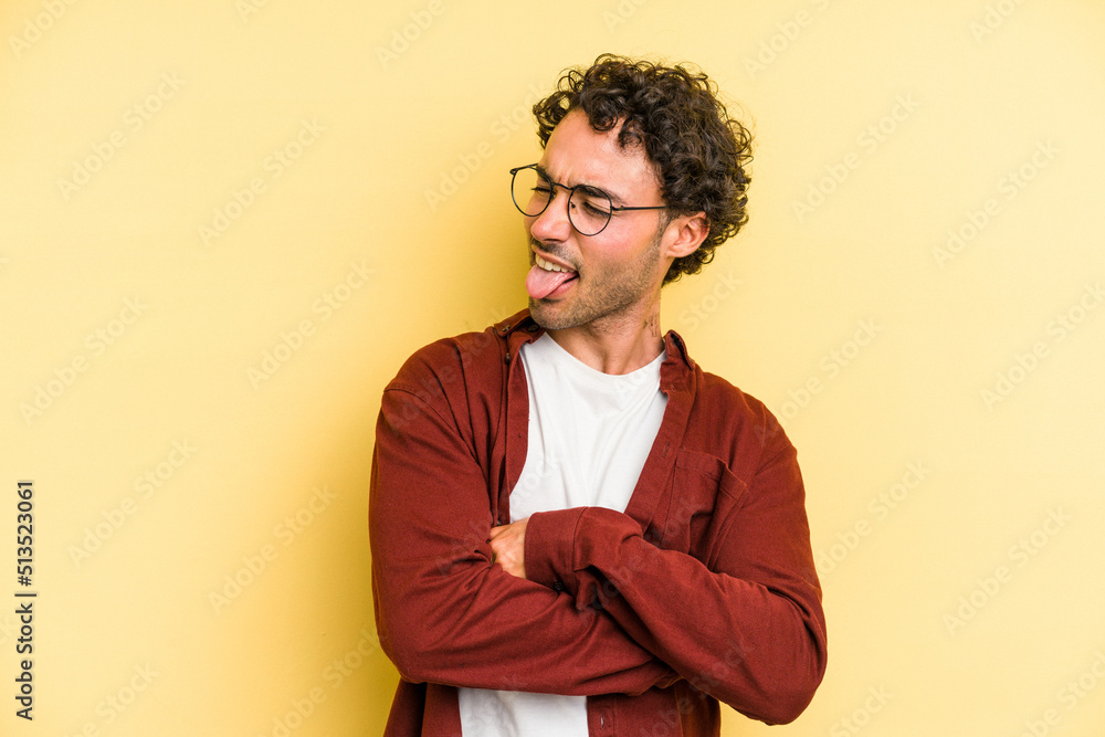 Young caucasian man isolated on yellow background funny and friendly sticking out tongue. Young caucasian man isolated on yellow background funny and friendly sticking out tongue.