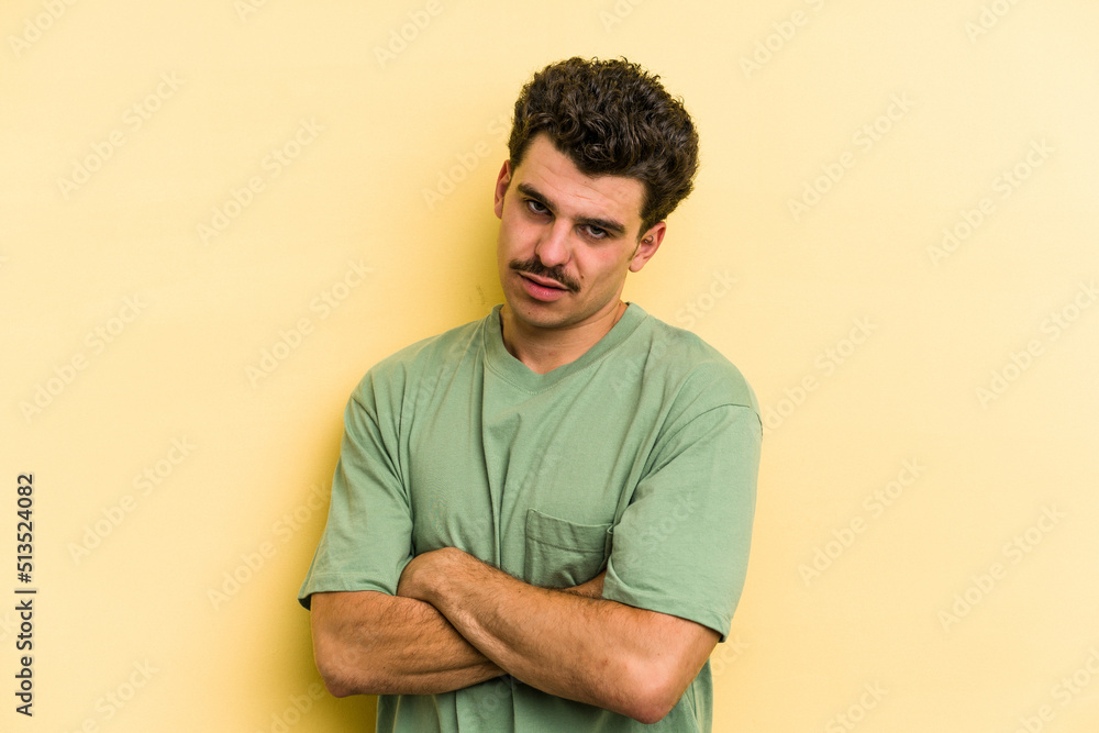 Young caucasian man isolated on yellow background who is bored, fatigued and need a relax day. Young caucasian man isolated on yellow background who is bored, fatigued and need a relax day.