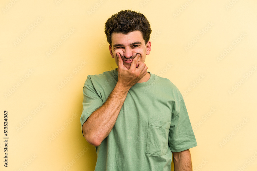 Young caucasian man isolated on yellow background doubting between two options. Young caucasian man isolated on yellow background doubting between two options.