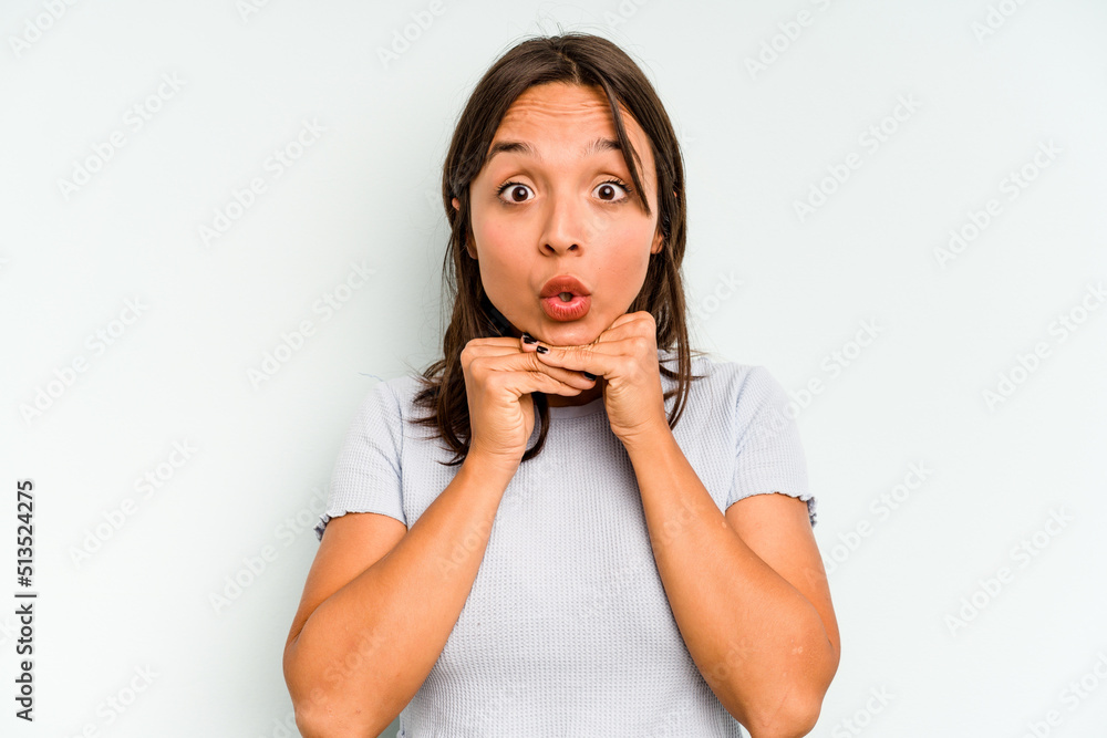 Young hispanic woman isolated on blue background holds copy space on a palm, keep hand over cheek. Amazed and delighted. Young hispanic woman isolated on blue background holds copy space on a palm, keep hand over cheek. Amazed and delighted.