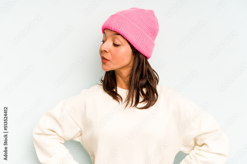 Young hispanic woman isolated on blue background holding and showing a product on hand. Young hispanic woman isolated on blue background holding and showing a product on hand.