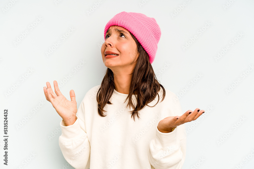 Young hispanic woman isolated on blue background touches tummy, smiles gently, eating and satisfaction concept. Young hispanic woman isolated on blue background touches tummy, smiles gently, eating and satisfaction concept.