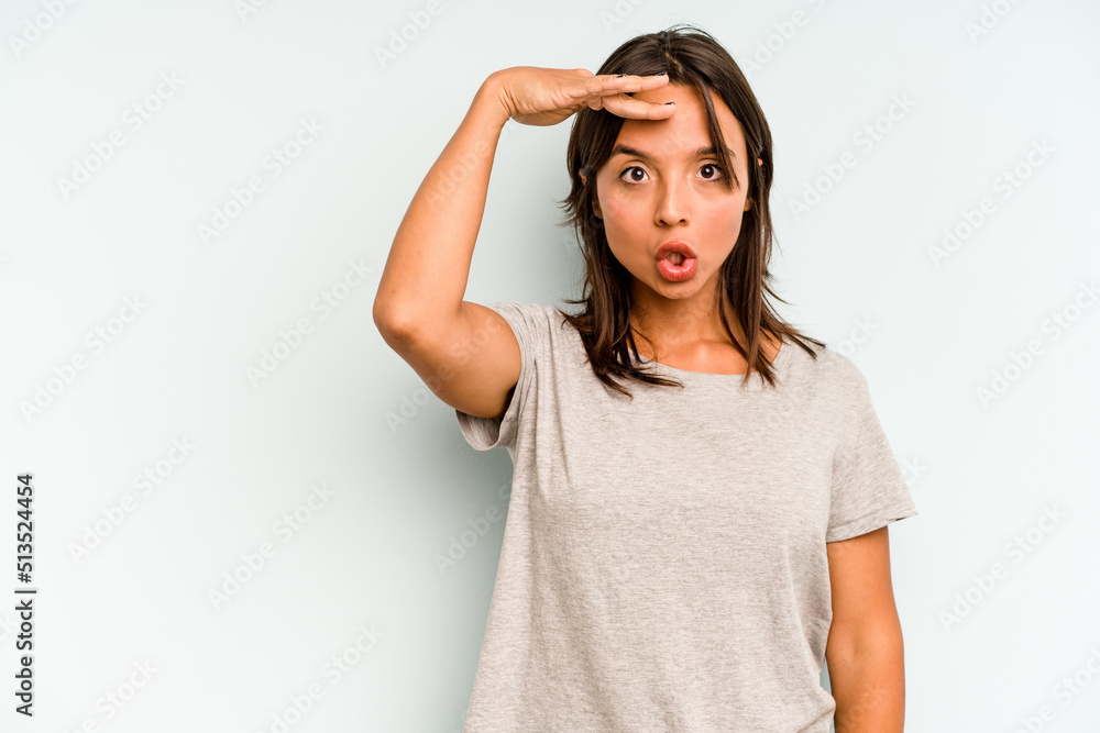 Young hispanic woman isolated on blue background folding lips and holding palms to send air kiss. Young hispanic woman isolated on blue background folding lips and holding palms to send air kiss.