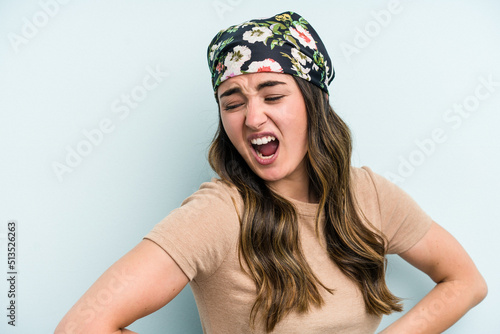 Young caucasian woman isolated on blue background suffering a back pain.