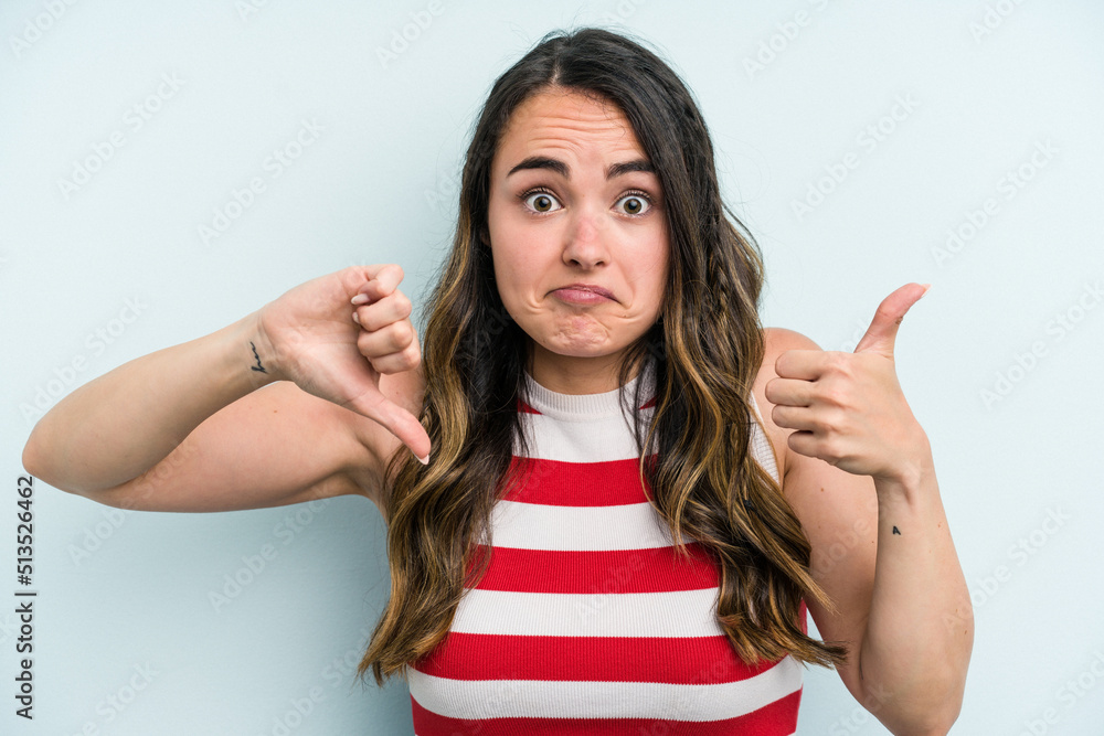 Fototapeta premium Young caucasian woman isolated on blue background showing thumbs up and thumbs down, difficult choose concept