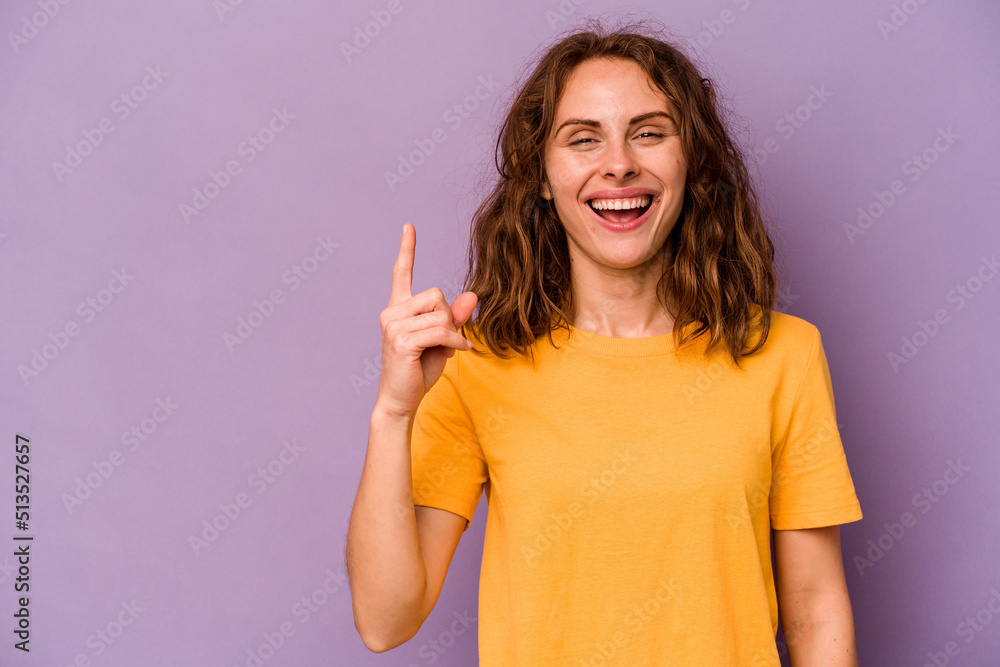Young caucasian woman isolated on purple background showing number one with finger. Young caucasian woman isolated on purple background showing number one with finger.