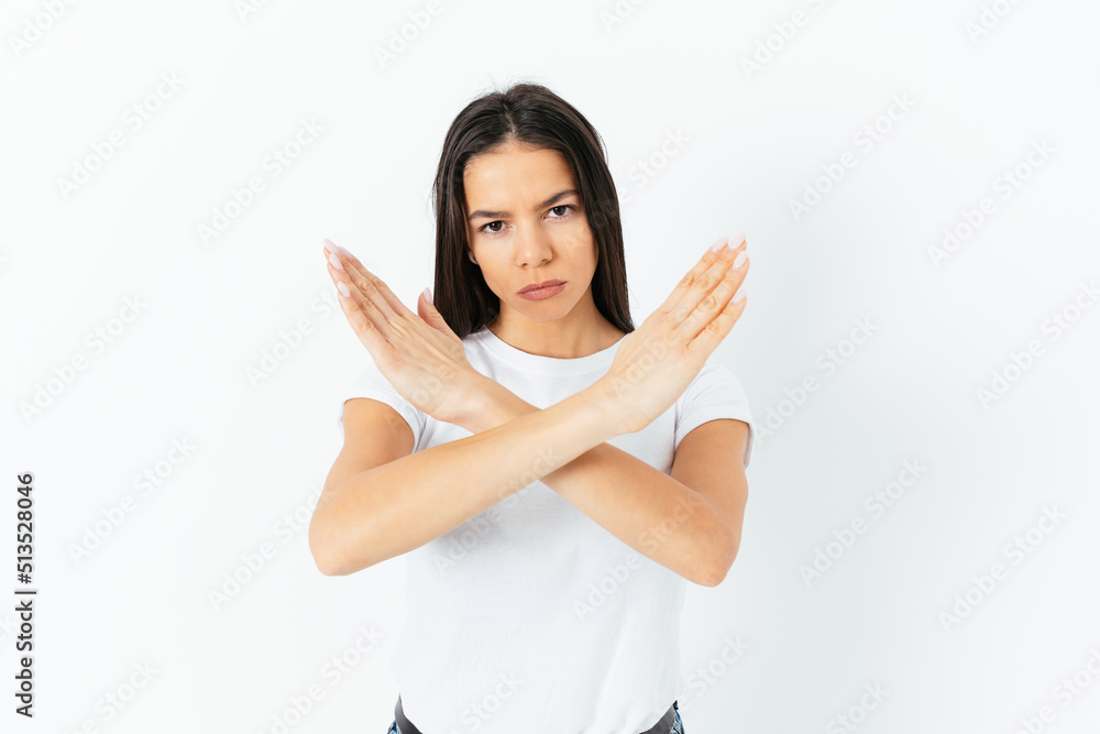 Young serious woman shows crossed arms in sign Young serious woman shows crossed arms in sign