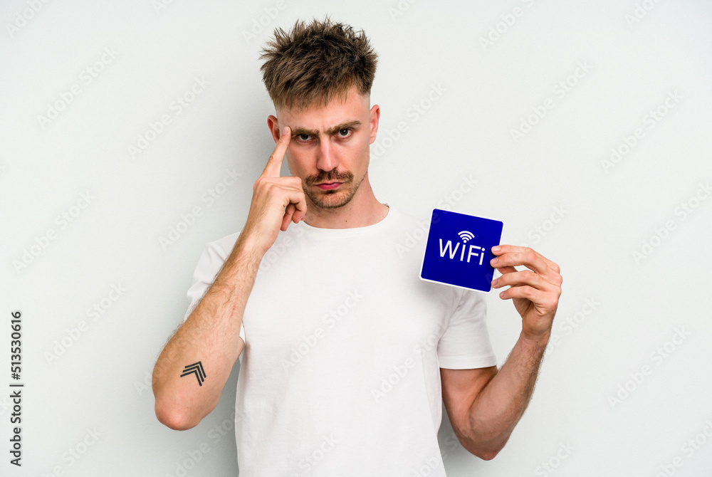 Young caucasian man holding wifi placard isolated on white background pointing temple with finger, thinking, focused on a task. Young caucasian man holding wifi placard isolated on white background pointing temple with finger, thinking, focused on a task.