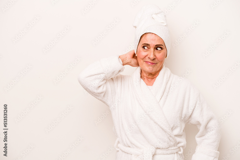 Middle age caucasian woman wearing a bathrobe isolated on white background touching back of head, thinking and making a choice. Middle age caucasian woman wearing a bathrobe isolated on white background touching back of head, thinking and making a choice.
