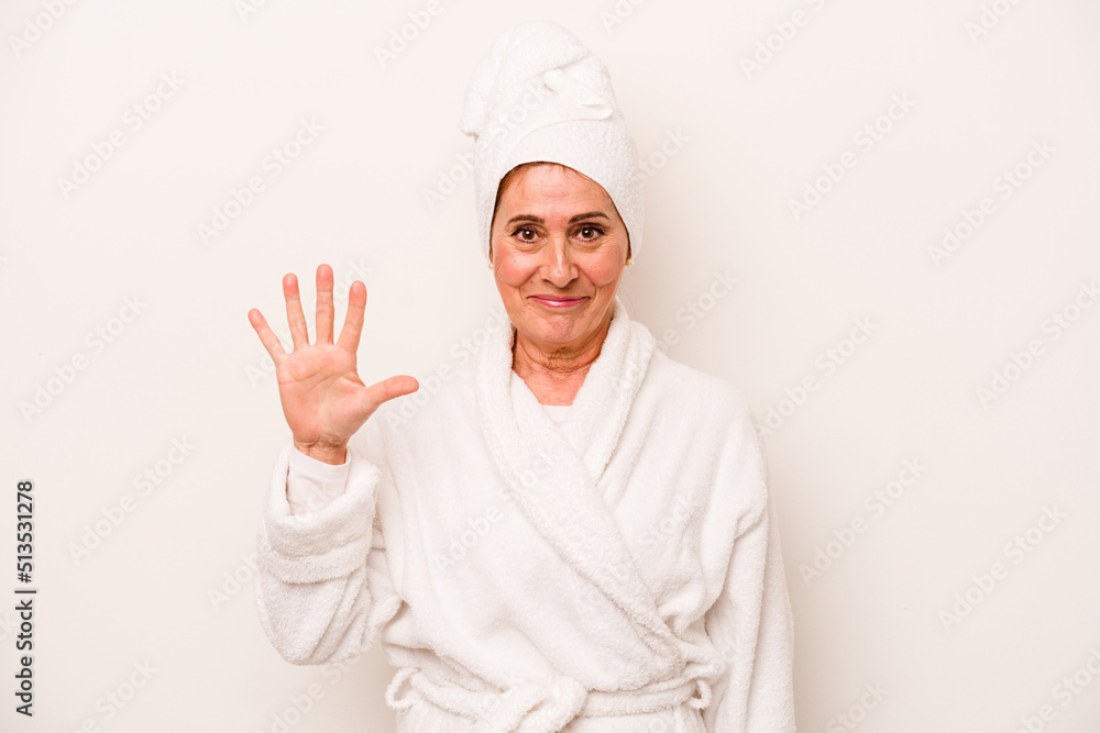 Middle age caucasian woman wearing a bathrobe isolated on white background smiling cheerful showing number five with fingers.