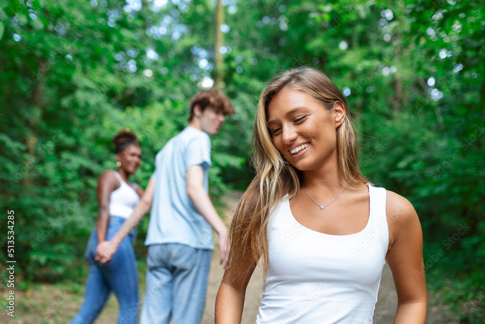 Disloyal man looking at another woman while walking with his girlfriend in park Disloyal man looking at another woman while walking with his girlfriend in park