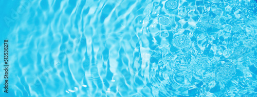 Pure clear water background. Ripples of aqua. Bubbles reflect light on the water surface. Blue banner backdrop. Fresh clean and moisturized. © Win Nondakowit