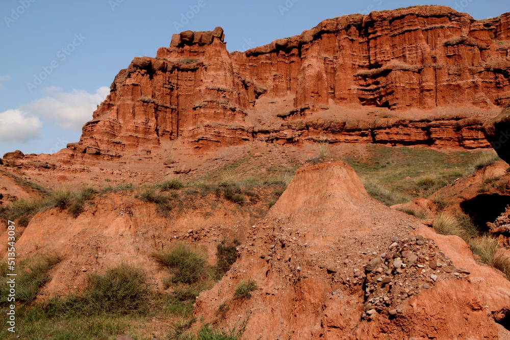 Fototapeta premium Landscape with red mountains Narman Peribacalari, formed due to erosion and weathering, against the blue sky with clouds, near the city of Erzurum, in the region of Eastern Anatolia, Turkey