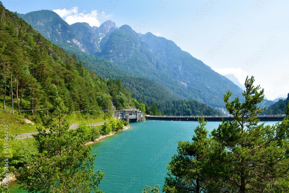 View of Lago di Cadore lake in Veneto region and Belluno province in Italy and a hydroelectric power plant and mountains rising above the lake