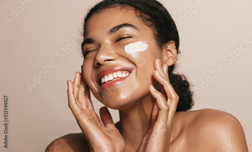 Print op canvas Smiling woman using skincare product