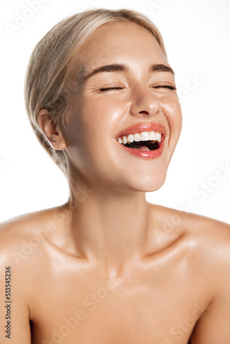 Dental care and beauty. Vertical of laughing happy woman with perfect white teeth, natural smile, glowing healthy facial skin, standing over white background