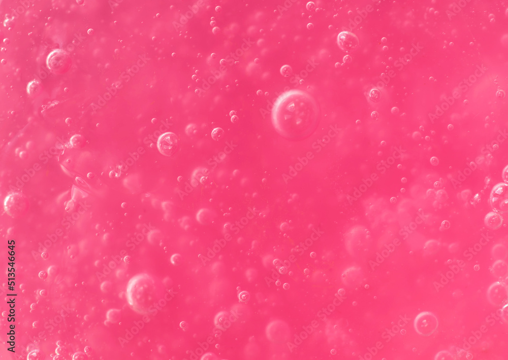 Texture of transparent pink gel with air bubbles and waves on white background. Concept of skin moisturizing, body care, and prevention of viruses. Liquid beauty product closeup. Backdrop, flat lay