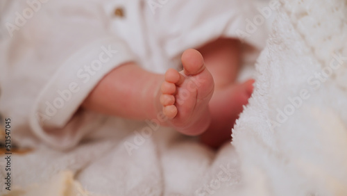 Little tender legs of newborn baby lying on blanket. Child waves legs. Caucasian nationality. Motherhood. Paternity. Happiness to be mom and dad. Continuation of genus. Love and concern. Soft focus