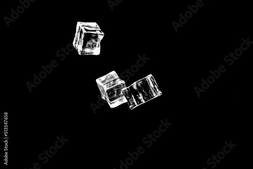 Ice cubes on a black background. ice falling on a black background for use as an illustration in a project