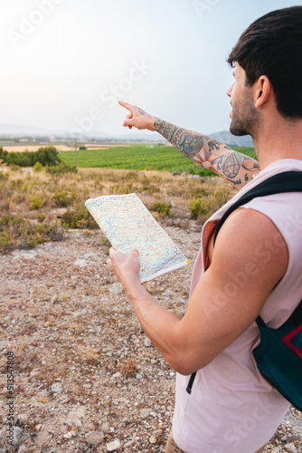 Close-up of a man pointing to the horizon with a map