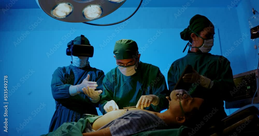 Surgeon and Group doctor assistant are performing abdominal surgery on patients in emergency operating room. Expert medical team uses modern treatment technology virtual reality glasses for surgery. Surgeon and Group doctor assistant are performing abdominal surgery on patients in emergency operating room. Expert medical team uses modern treatment technology virtual reality glasses for surgery.