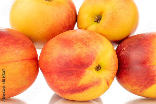 Several juicy organic nectarines, close-up, isolated on a white background.